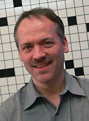 Will Shortz against a background of crossword squares